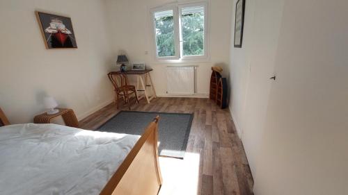 a bedroom with a bed and a window and a table at Galaxie in Arcachon