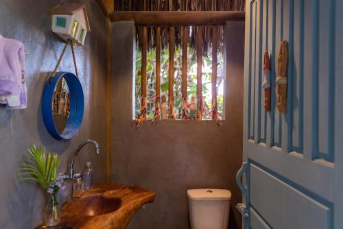un bagno con lavandino, WC e finestra di Casa Serendipity Trancoso a Porto Seguro