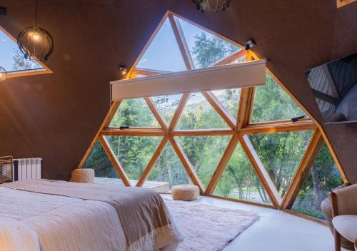 a large window in a bedroom with a large bed at Guardianes Del Bayo in Villa La Angostura