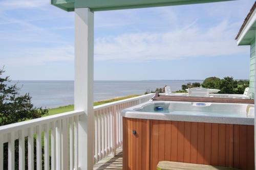 a hot tub on a deck with a view of the ocean at Links End in Nags Head