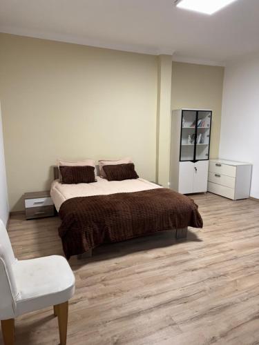 a bedroom with a large bed and a white chair at Spacious villa in Rabat
