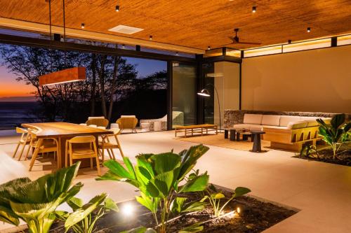 an open patio with a table and a couch at Casa Lagom, Luxurious Oasis with Infinity Pool! in La Cruz
