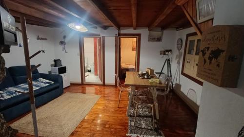 a living room with a blue couch and a table at Orion Guesthouse Telhado in Fundão