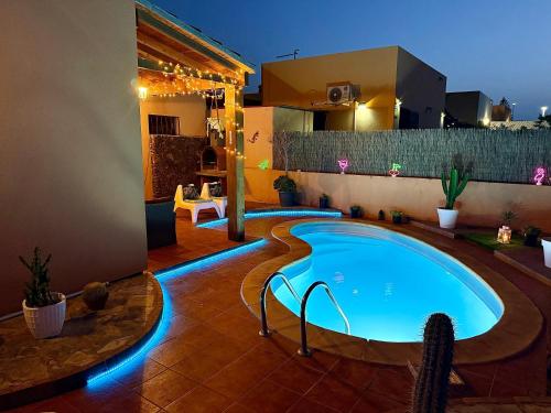 una piscina en medio de un patio trasero por la noche en Nur house villa and private pool, en La Oliva
