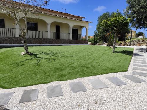 a large yard with a house and a lawn at Casa do Algarvito in Terrugem
