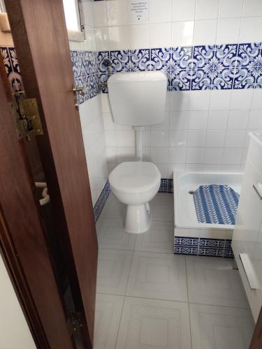a small bathroom with a toilet and a tub at Casa do Algarvito in Terrugem