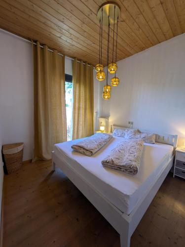 a large white bed in a bedroom with a wooden ceiling at Villa Steinmetz in Kiefersfelden