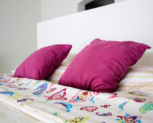 2 cuscini viola posti sopra un letto di Villa con Alberca Princess ad Acapulco