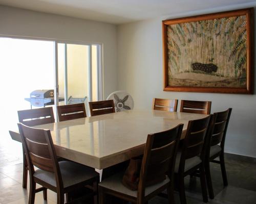 tavolo da pranzo con sedie e dipinto sul muro di Villa con Alberca Princess ad Acapulco