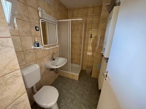 a small bathroom with a toilet and a sink at Yellow Bridge Vendégház in Gárdony