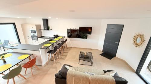 une cuisine et un salon avec un canapé et une table dans l'établissement Bessan Villa Jungle 6p 3ch Pool Garden, à Bessan