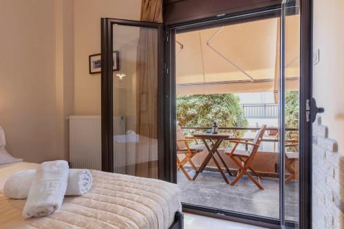 a bedroom with a bed and a balcony with a table at Mpalkoni Sti Monemvasia in Monemvasia