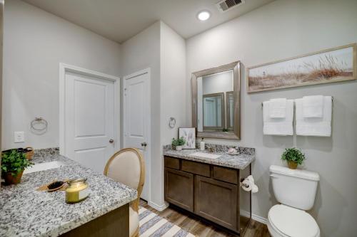a bathroom with a toilet and a sink and a mirror at 4BR Spacious Family Retreat, 5min Lake Conroe, Large Backyard Grill in Montgomery
