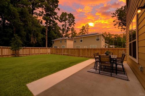 a patio with a table and chairs in a backyard at 4BR Spacious Family Retreat, 5min Lake Conroe, Large Backyard Grill in Montgomery