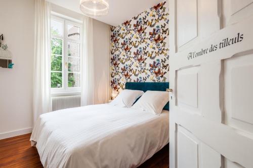 een slaapkamer met een wit bed en bloemenbehang bij Chambre d'hôtes Du côté des remparts in Wissembourg