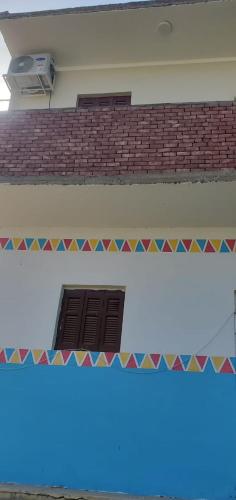 a building with a window and a roof with colorful tiles at Habob Nubian Guest House in Aswan