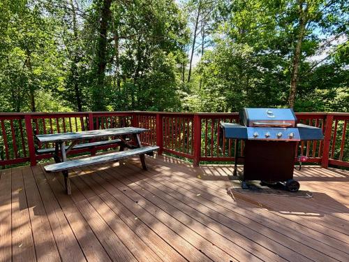 a grill and a picnic table on a deck at Sleeps 22, mountain view, game room, pet friendly! in Sevierville