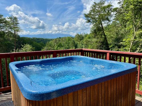a hot tub on the deck of a house at Sleeps 22, mountain view, game room, pet friendly! in Sevierville