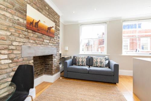 a living room with a couch and a brick wall at Stylish Soho Apartment R2 in London