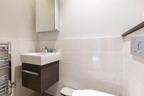 a white bathroom with a sink and a toilet at Stylish Soho Apartment R2 in London