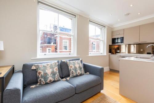 a living room with a couch and a kitchen at Stylish Soho Apartment R2 in London