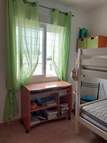 a bedroom with a window with green curtains at Bella in Oliva