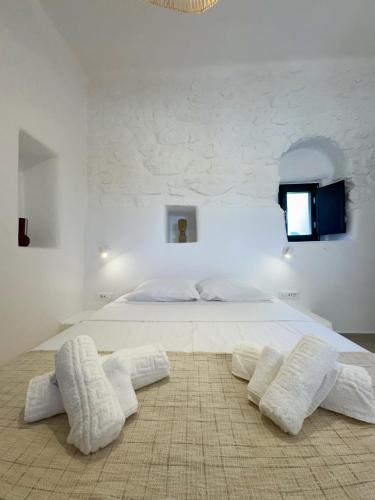a bedroom with a large white bed with two white towels at Kukulú Luxurious Cottage with Mini Private Pool in Ano Mera