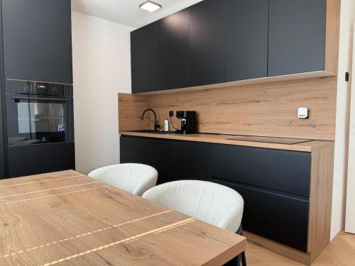 a kitchen with a wooden counter and a table and chairs at Moderno stanovanje - Ptuj in Ptuj