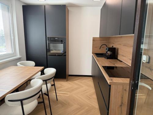 a kitchen with a counter and a table and chairs at Moderno stanovanje - Ptuj in Ptuj