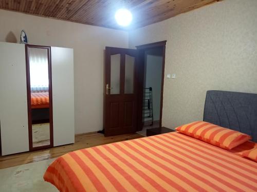 a bedroom with a bed with an orange striped blanket at Hamsiköy green garden in Trabzon