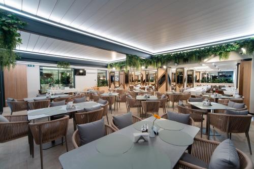 a restaurant with white tables and chairs at Hotel Dorna in Vatra Dornei
