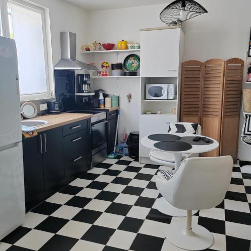- une cuisine avec un sol en damier noir et blanc dans l'établissement Petite maison mitoyenne, proche port & Arcachon, à La Teste-de-Buch