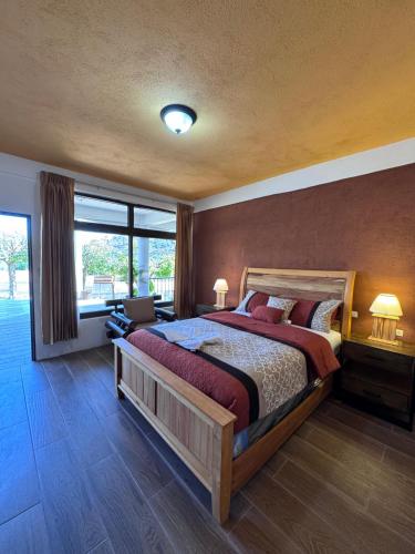 a bedroom with a large bed and a large window at Hotel Mercy in San Juan La Laguna