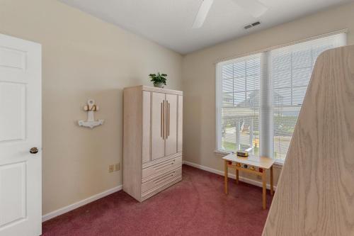 a room with a cabinet and a desk and a window at Skippers Landing in Manteo