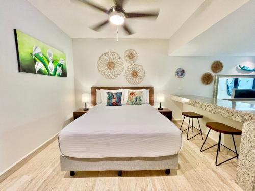 a bedroom with a bed and a ceiling fan at Syrena Condo Rentals in Playa del Carmen
