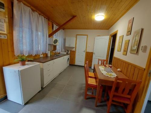 a kitchen with a table and chairs and a refrigerator at Family vendégház in Túrkeve