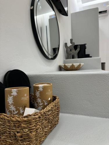 a basket of candles on a counter with a mirror at Olive Garden Hotel in Agios Prokopios