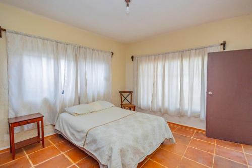 a bedroom with a bed and two large windows at NEW Bamboo Villa Palma Pool and Rest in Chiconcuac