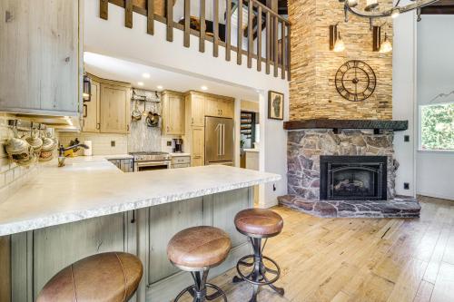 a kitchen with a fireplace and two bar stools at Walk to Diamond Peak Luxe Chalet with Mtn-View Deck in Incline Village