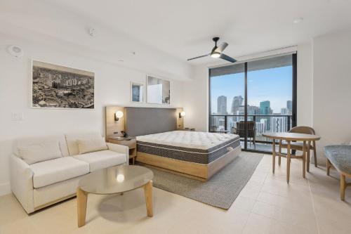 a bedroom with a bed and a couch and a table at NEW Luxury Bay View Downtown Studio in Miami