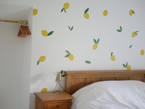 a bedroom with a bed and a white wall with decals at Moulin de Saint Jacques 