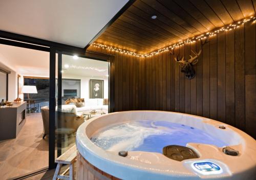 una grande vasca in una stanza con soggiorno di The Glasshouse by MajorDomo - Central Home with Hot Tub & Sauna a Queenstown