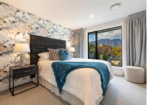 una camera da letto con un letto grande e una finestra di The Glasshouse by MajorDomo - Central Home with Hot Tub & Sauna a Queenstown