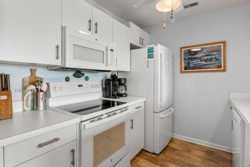 a kitchen with white appliances and a white refrigerator at The Hook in Manteo