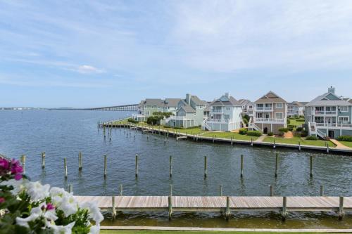 a row of houses on a dock next to the water at The Hook in Manteo