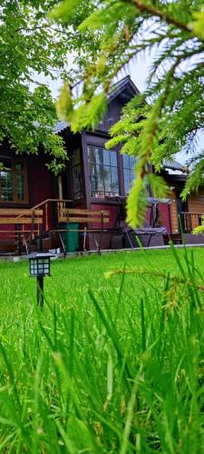 a bench in the grass in front of a house at Mover mount apart in Skole