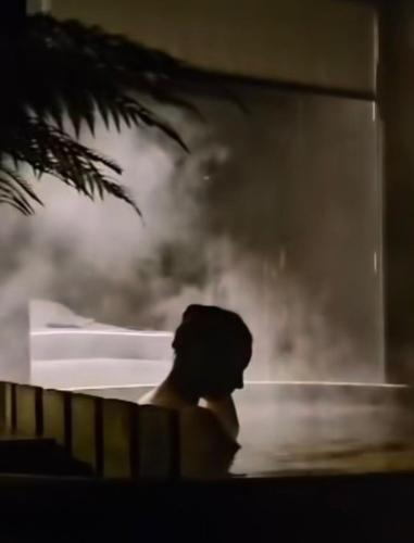 a man sitting in the water in a bath tub at Calma Cabins in Puerto Clocker