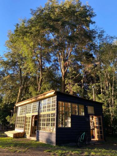 a small house with a lot of windows at Calma Cabins in Puerto Clocker