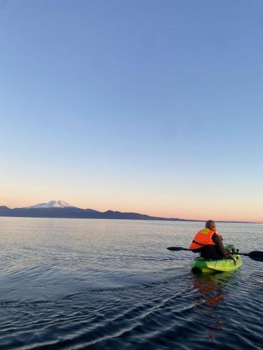a man sitting on a kayak in the water at Calma Cabins in Puerto Clocker
