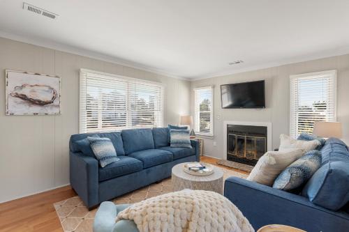 a living room with two blue couches and a fireplace at Slumbering Duck in Sanderling